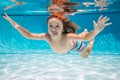 Child swims underwater in swimming pool, happy active boy dives and has fun under water, kids watersport. Summer