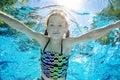 Child swims underwater in swimming pool, happy active teenager girl dives and has fun under water, kid fitness and sport Royalty Free Stock Photo