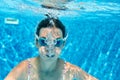 Child swims underwater in swimming pool, happy active teenager girl dives and has fun under water, kid fitness and sport Royalty Free Stock Photo