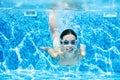 Child swims underwater in swimming pool, happy active teenager girl dives and has fun under water, kid fitness and sport Royalty Free Stock Photo