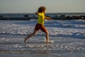 Child in swimwear running into sea water during summer holidays. Child running along ocean. Child on summer beach. Kid Royalty Free Stock Photo