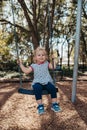 Child on a swing. Child playing on outdoor playground.