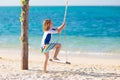 Child on swing. Kid swinging on beach Royalty Free Stock Photo