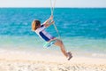 Child on swing. Kid swinging on beach Royalty Free Stock Photo