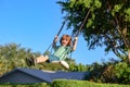 Child swing outdoor. Kid playing on backyard. Happy cute little boy swinging and having fun healthy summer vacation Royalty Free Stock Photo