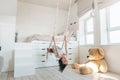 Child swinging in bright scandinavian playroom