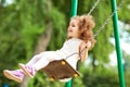 Child swinging on a swing at playground in the park.