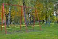 Child swings in park in autumn
