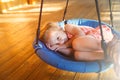Child swings on a swing chaise longue.