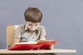 The child at the table is doing homework. Royalty Free Stock Photo