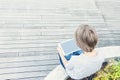 Child with tablet computer sitting outdoors. Top view Royalty Free Stock Photo