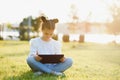 Child with tablet pc outdoors. Little girl on grass with computer Royalty Free Stock Photo