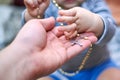 A child takes a rosary from his dad`s hand