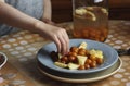 Child taking a piece of stewed fruit of compote- zucchini and cherry plum on the plate Royalty Free Stock Photo