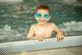 Child, taking swimming lessons in a group of children in indoor pool Royalty Free Stock Photo