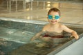 Child, taking swimming lessons in a group of children in indoor pool Royalty Free Stock Photo