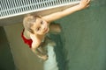 Child, taking swimming lessons in a group of children in indoor pool Royalty Free Stock Photo