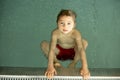 Child, taking swimming lessons in a group of children in indoor pool Royalty Free Stock Photo
