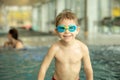 Child, taking swimming lessons in a group of children in indoor pool Royalty Free Stock Photo