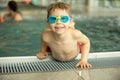 Child, taking swimming lessons in a group of children in indoor pool Royalty Free Stock Photo