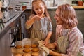 happy caucasian child girl taste cookies at home