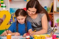 Children painting finger on easel. Group of kids with teacher. Royalty Free Stock Photo