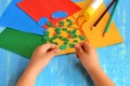 Child tearing colored paper into pieces. Home activity to improve fine motor skill development. Baby play. How to work with paper