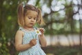 child tearing off flower petals while playing - loves or dislike