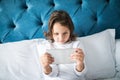Child, technology and internet concept - little girl lying in bed with smartphone and play games at home
