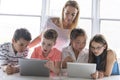 Child with technology tablet and laptop computer in classroom teacher on the background Royalty Free Stock Photo