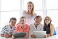 Child with technology tablet and laptop computer in classroom teacher on the background Royalty Free Stock Photo