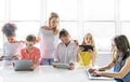 Child with technology tablet and laptop computer in classroom teacher on the background Royalty Free Stock Photo