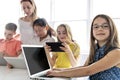 Child with technology tablet and laptop computer in classroom teacher on the background Royalty Free Stock Photo