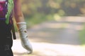 A child or teenage kid with its forearm in plaster cast goes hiking happily on a forest path lying in bright sun light.