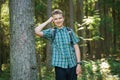 Teenager boy walking in the forest alone in the summer day