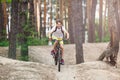 Child teenager in white t shirt and yellow shorts on bicycle ride in forest at spring or summer. Happy smiling Boy cycling outdoor