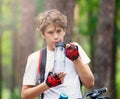 Child teenager in white t shirt and yellow shorts on bicycle ride in forest at spring or summer. Happy smiling Boy cycling outdoor Royalty Free Stock Photo