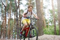Child teenager in white t shirt and yellow shorts on bicycle ride in forest at spring or summer. Happy smiling Boy cycling outdoor