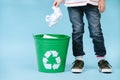 Child is throwing crumpled paper in recycling bin. Royalty Free Stock Photo