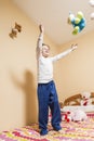 Child throwing a lot of stuffed animals in the air