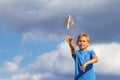 Boy throwing paper plane against blue sky Royalty Free Stock Photo