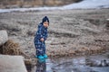 a child throws stones into the water