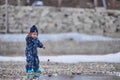 a child throws stones into the water