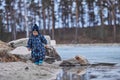 a child throws stones into the water