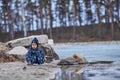 a child throws stones into the water