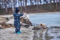 a child throws stones into the water