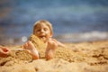 Child, tickling sibling on the beach on the feet with feather, kid cover in sand, smiling, laughing