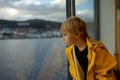 Child toddler boy on a ferry on a fjord, sunset on the deck of ferry on sunny day