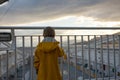 Child toddler boy on a ferry on a fjord, sunset on the deck of ferry on sunny day