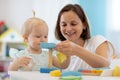 Child together with mother or babysitter playing toys